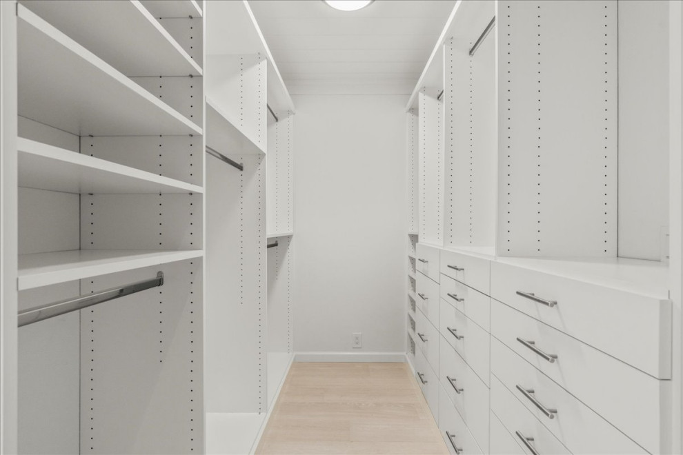 Design ideas for a large beach style gender neutral walk-in wardrobe in San Francisco with open cabinets, white cabinets, porcelain flooring and beige floors.