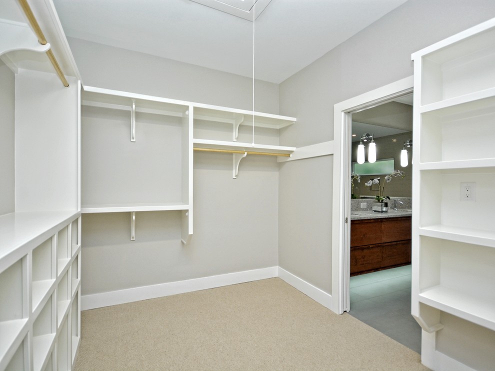Design ideas for a large midcentury gender-neutral walk-in wardrobe in Austin with open cabinets, white cabinets and carpet.