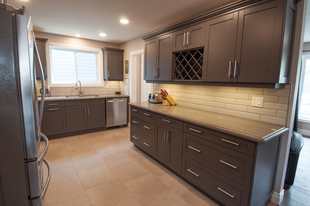 Mid-sized transitional u-shaped ceramic tile and beige floor enclosed kitchen photo in Toronto with a double-bowl sink, shaker cabinets, dark wood cabinets, quartzite countertops, beige backsplash, subway tile backsplash, stainless steel appliances and no island