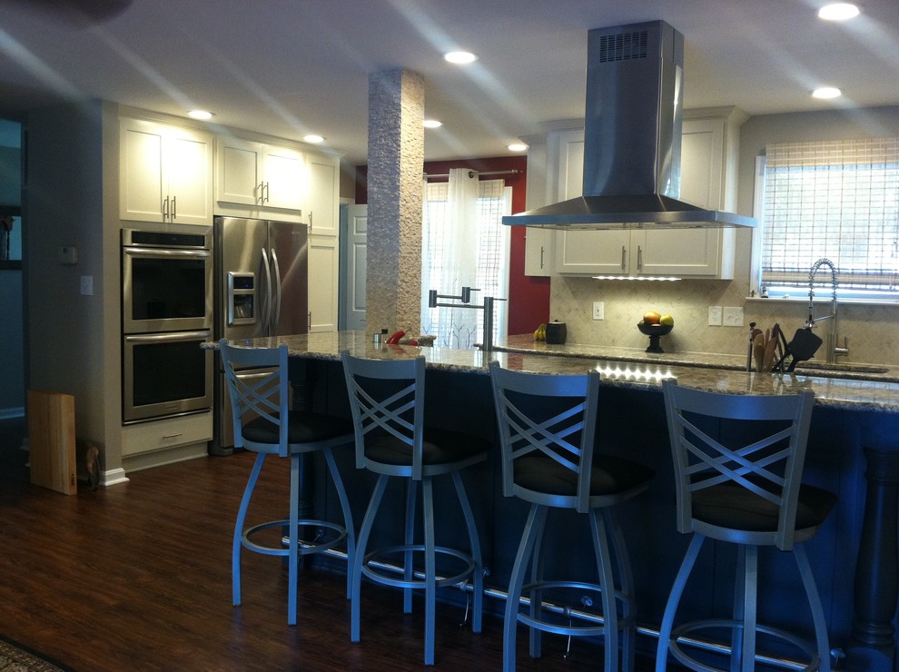 Inspiration for a mid-sized transitional dark wood floor open concept kitchen remodel in Baltimore with an undermount sink, white cabinets, quartz countertops, beige backsplash, stainless steel appliances, an island, recessed-panel cabinets and stone tile backsplash