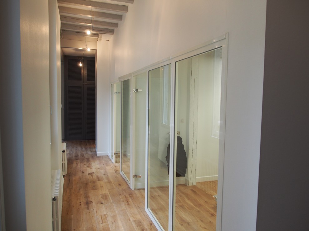 Exemple d'un petit couloir chic avec un mur gris et parquet clair.
