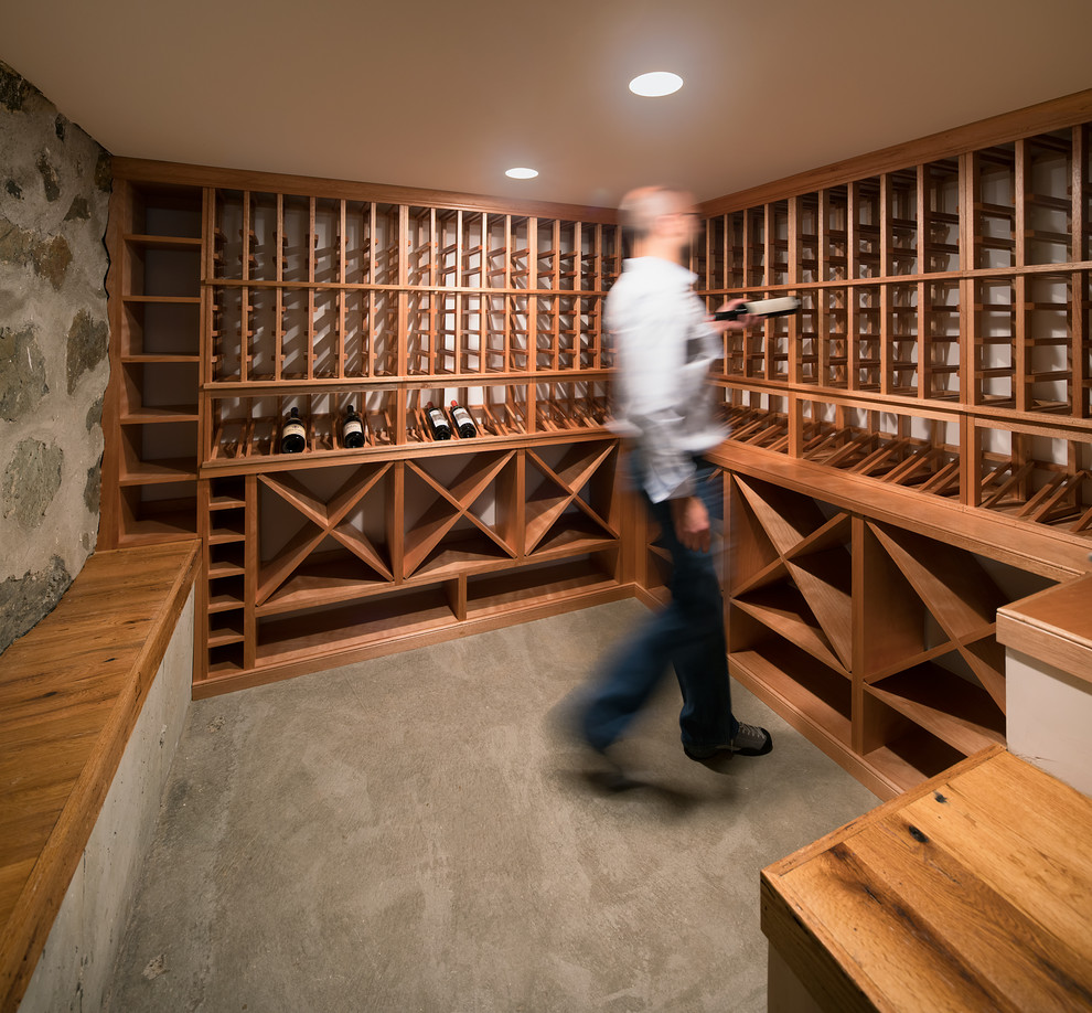 Small traditional wine cellar in Boston with concrete floors and storage racks.