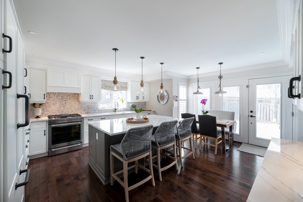 Inspiration for a transitional dark wood floor and brown floor kitchen remodel with white cabinets, paneled appliances, an island and white countertops