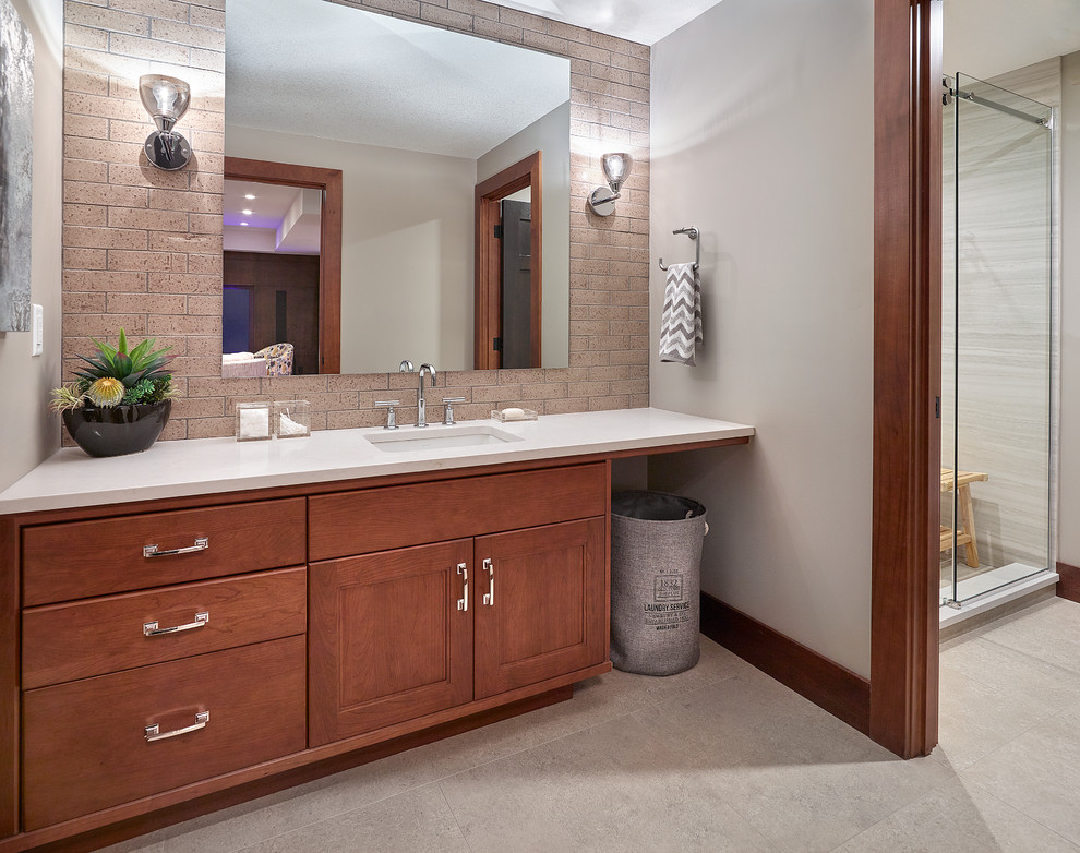 Mid-sized transitional kids' brown tile and ceramic tile ceramic tile and gray floor drop-in bathtub photo in Edmonton with recessed-panel cabinets, medium tone wood cabinets, gray walls, a drop-in sink and quartz countertops