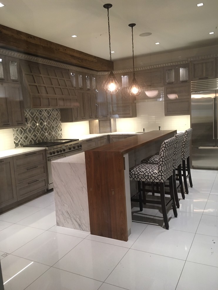 Inspiration for an expansive modern l-shaped eat-in kitchen in Bridgeport with a single-bowl sink, flat-panel cabinets, grey cabinets, marble benchtops, white splashback, ceramic splashback, stainless steel appliances, porcelain floors, with island, white floor and white benchtop.