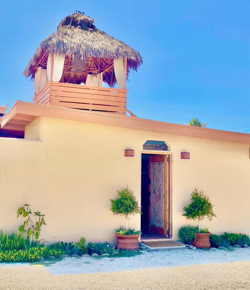 Foto di una piccola porta d'ingresso costiera con pareti arancioni, pavimento in terracotta, una porta singola, una porta in legno chiaro, pavimento arancione e travi a vista