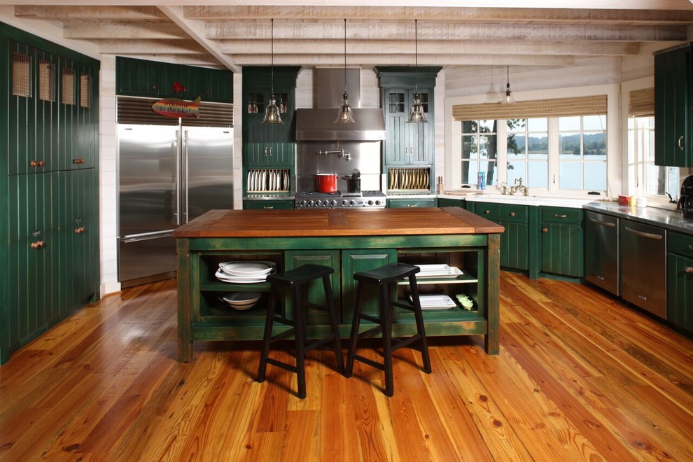 Large mountain style l-shaped medium tone wood floor open concept kitchen photo with a drop-in sink, green cabinets, white backsplash, stainless steel appliances, an island and stainless steel countertops