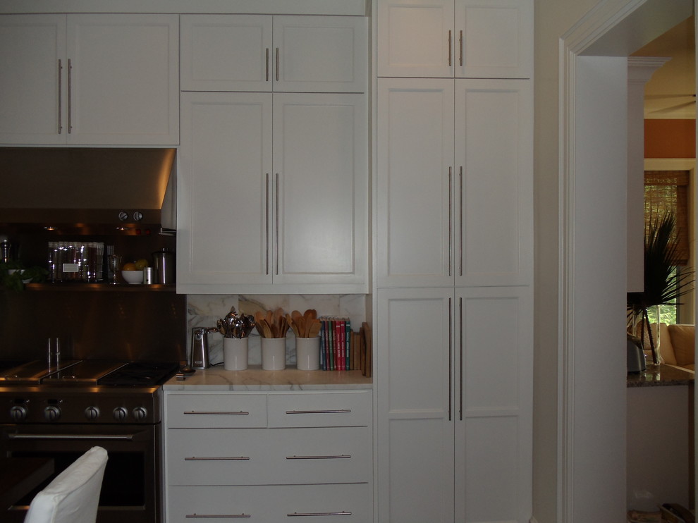 Inspiration for a mid-sized transitional u-shaped cork floor eat-in kitchen remodel with an undermount sink, flat-panel cabinets, white cabinets, marble countertops, stone tile backsplash, stainless steel appliances and an island