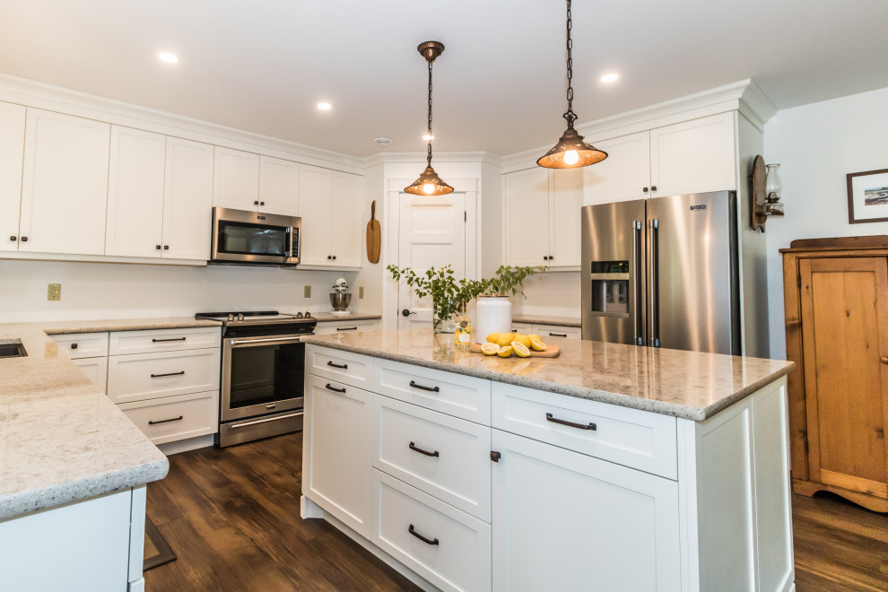 Inspiration for a mid-sized u-shaped vinyl floor and brown floor kitchen remodel with an undermount sink, recessed-panel cabinets, white cabinets, quartzite countertops, stainless steel appliances, an island and beige countertops