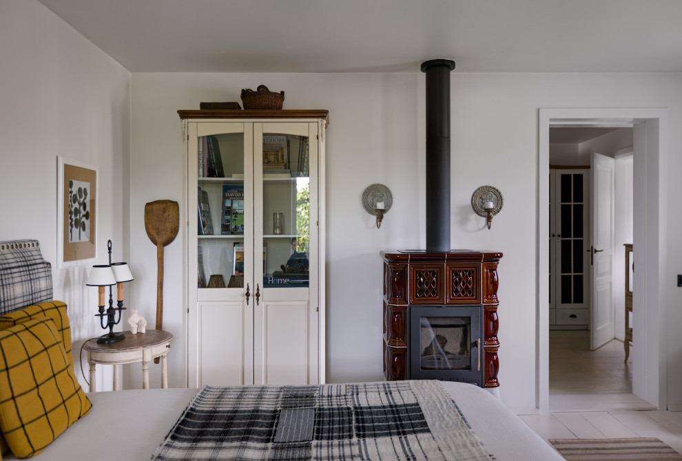 Foto på ett litet skandinaviskt huvudsovrum, med vita väggar, målat trägolv, en standard öppen spis, en spiselkrans i trä och vitt golv