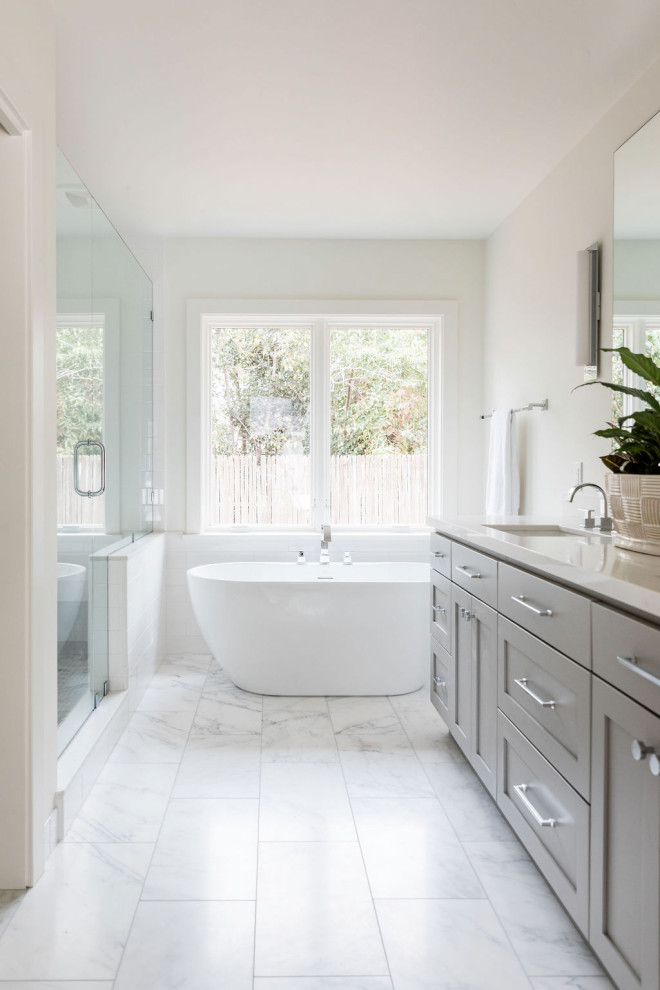 Design ideas for a mid-sized transitional master bathroom in Sacramento with shaker cabinets, grey cabinets, a freestanding tub, an alcove shower, white walls, an undermount sink, white floor, a hinged shower door and white benchtops.