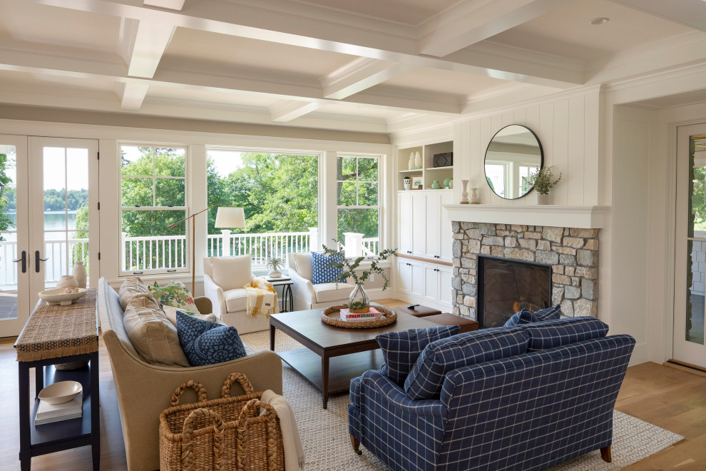 Inspiration for a large coastal open concept light wood floor and coffered ceiling family room remodel in Minneapolis with beige walls, a standard fireplace, a stone fireplace and a concealed tv