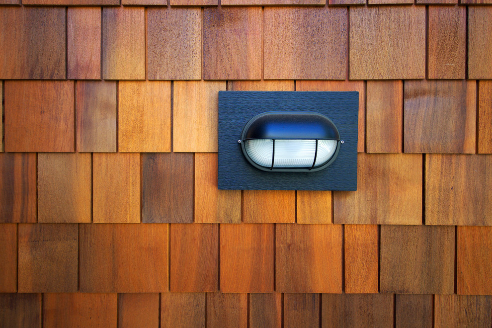 Example of a mountain style brown two-story concrete fiberboard exterior home design in Vancouver with a clipped gable roof