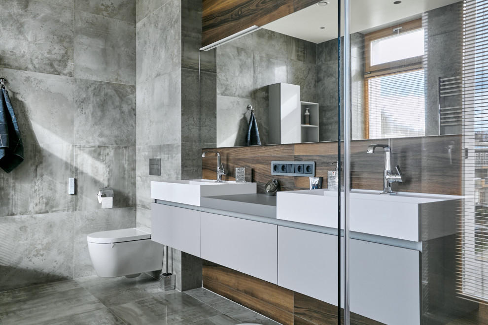 Trendy gray tile and porcelain tile porcelain tile, gray floor and double-sink freestanding bathtub photo in Moscow with flat-panel cabinets, gray cabinets, a wall-mount toilet, gray walls, white countertops and a floating vanity