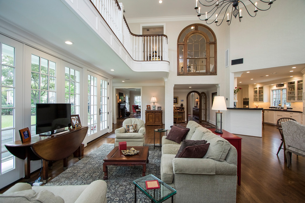 This is an example of an expansive transitional open concept family room in Houston with white walls and dark hardwood floors.