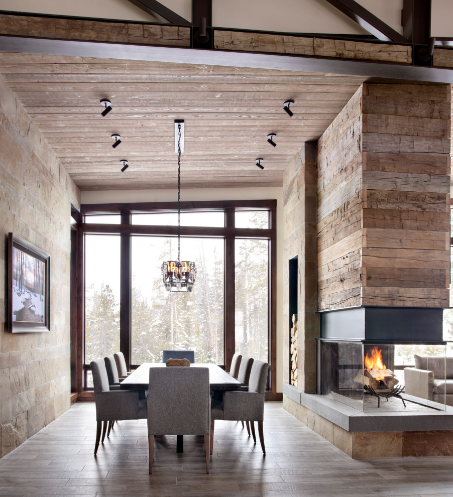 This is an example of a country open plan dining in Other with a two-sided fireplace.
