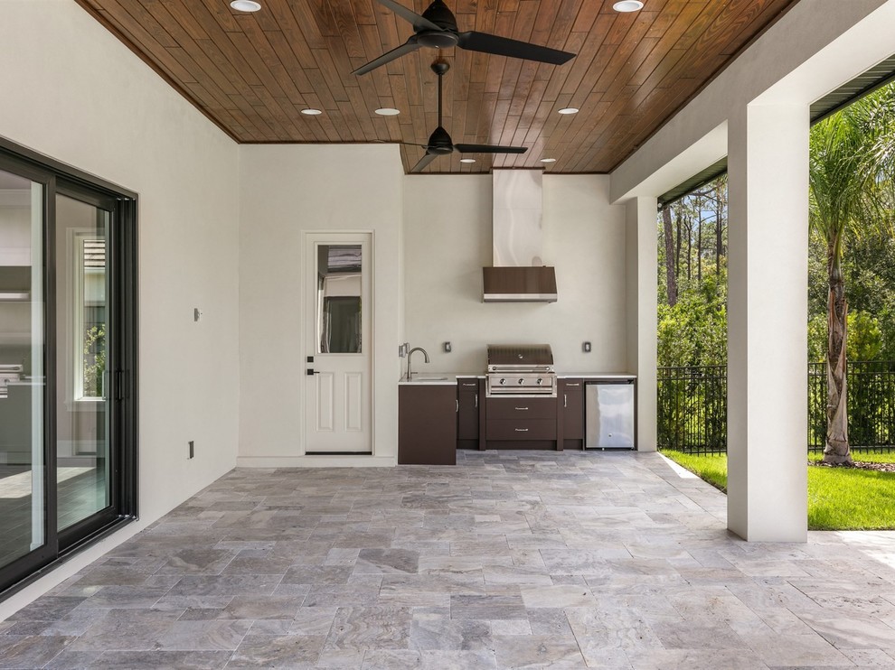 Example of a mid-sized transitional backyard tile patio kitchen design in Orlando with a roof extension