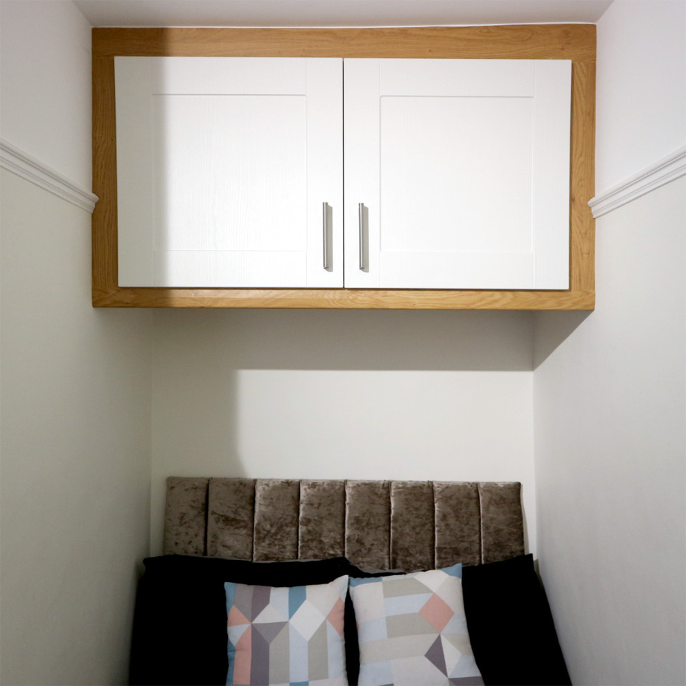 Immagine di una piccola camera matrimoniale moderna con pareti bianche, moquette e pavimento beige