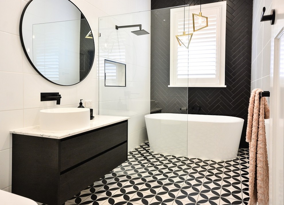 Photo of a mid-sized contemporary master bathroom in Brisbane with flat-panel cabinets, dark wood cabinets, a freestanding tub, an open shower, black tile, white tile, white walls, a vessel sink, multi-coloured floor, an open shower and beige benchtops.