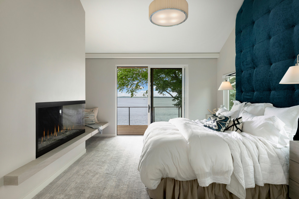 This is an example of a contemporary master bedroom in Minneapolis with white walls, carpet, a two-sided fireplace, a metal fireplace surround, grey floors and a vaulted ceiling.