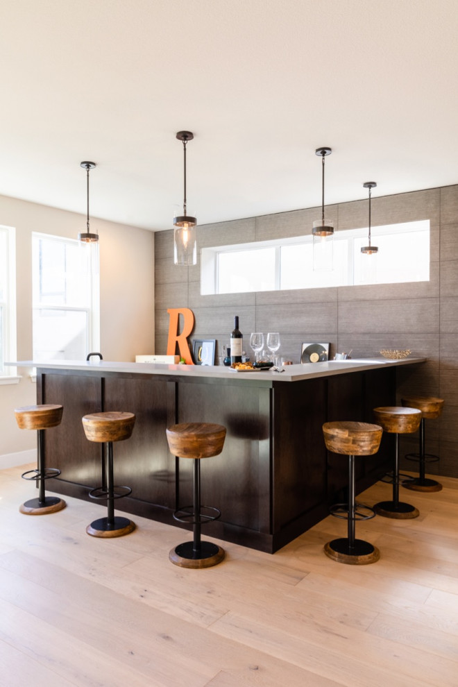 This is an example of a mid-sized contemporary l-shaped wet bar in Denver with an undermount sink and light hardwood floors.
