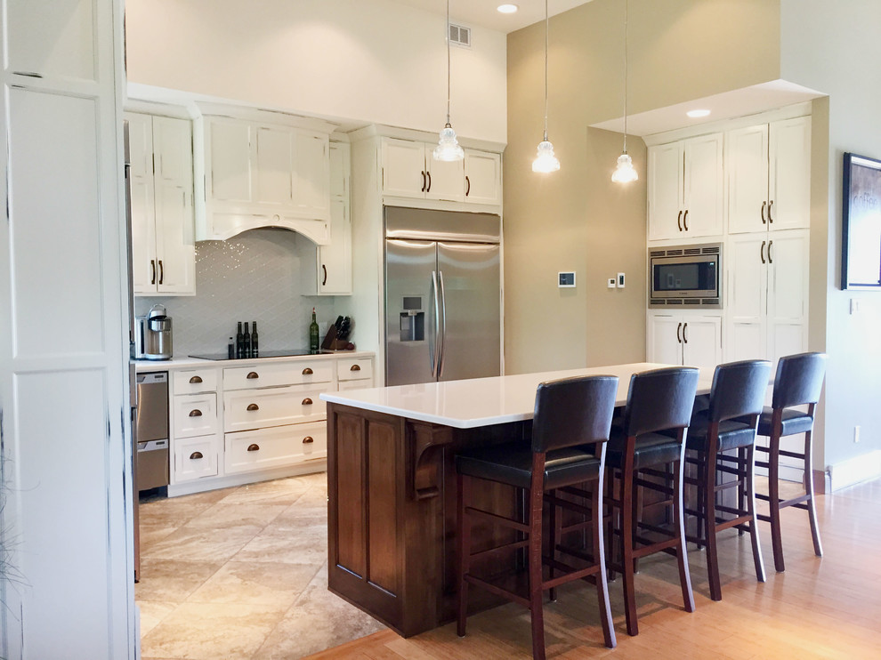 Large transitional l-shaped limestone floor and gray floor open concept kitchen photo with shaker cabinets, white cabinets, quartzite countertops, white backsplash, porcelain backsplash, stainless steel appliances, an island and white countertops