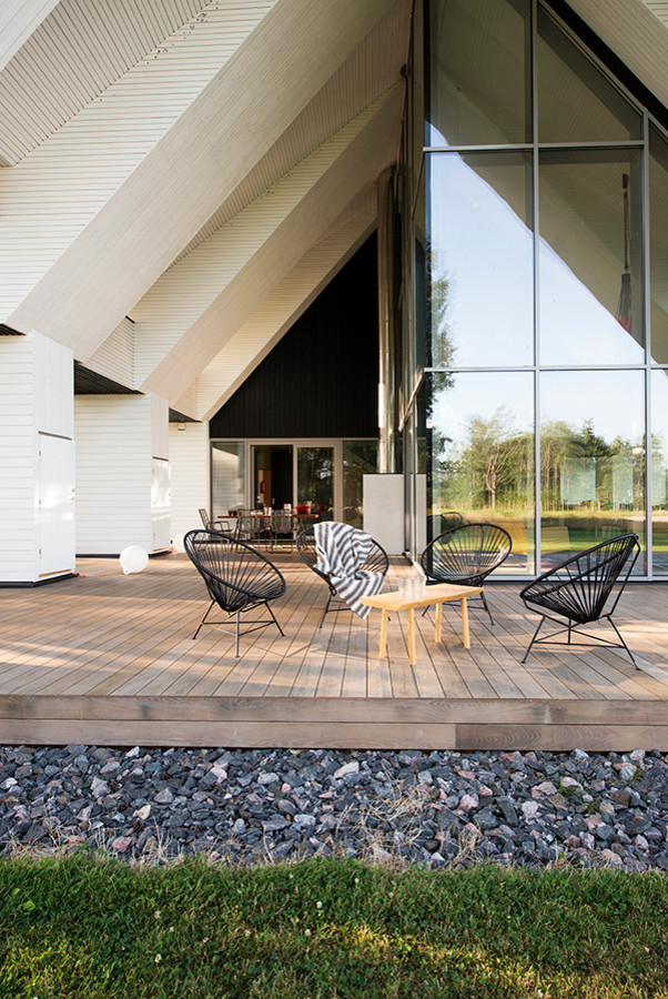 Photo of an expansive scandinavian deck in Other with a roof extension.