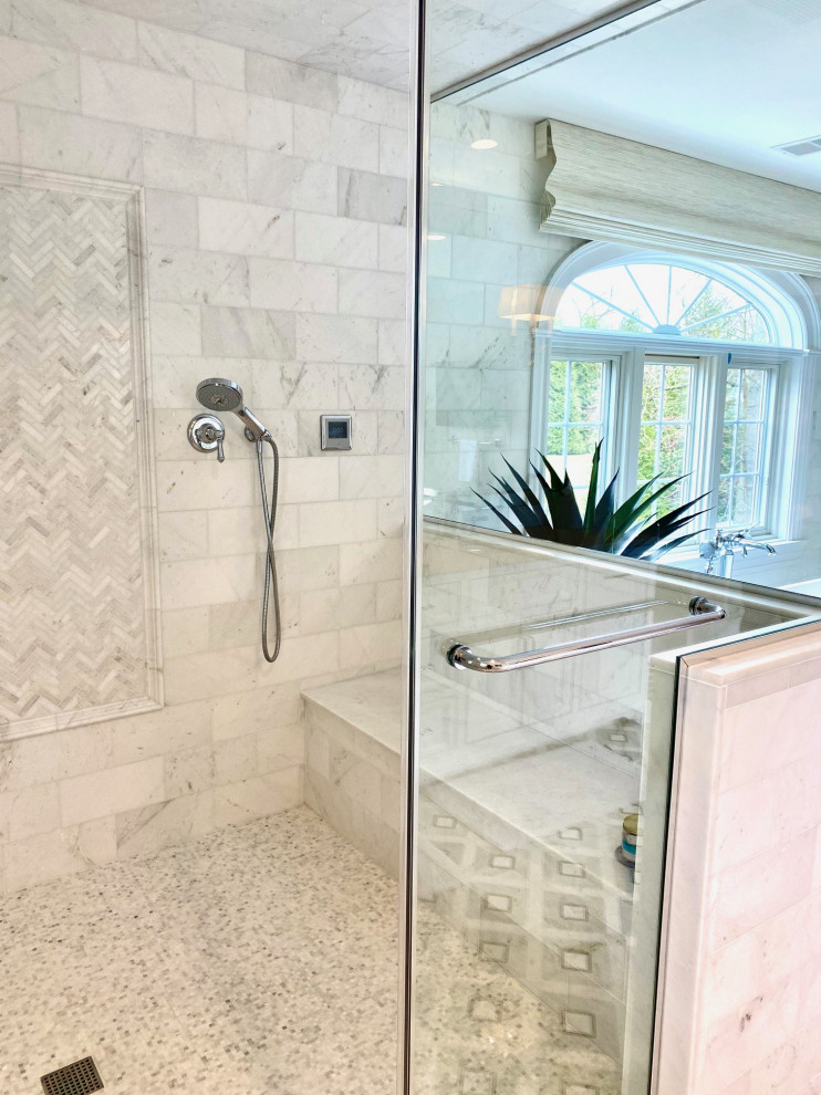 Photo of a large transitional master bathroom in New York with recessed-panel cabinets, white cabinets, a freestanding tub, a double shower, a two-piece toilet, white tile, marble, grey walls, marble floors, an undermount sink, quartzite benchtops, grey floor, a hinged shower door, white benchtops, a shower seat, a double vanity, a built-in vanity and brick walls.