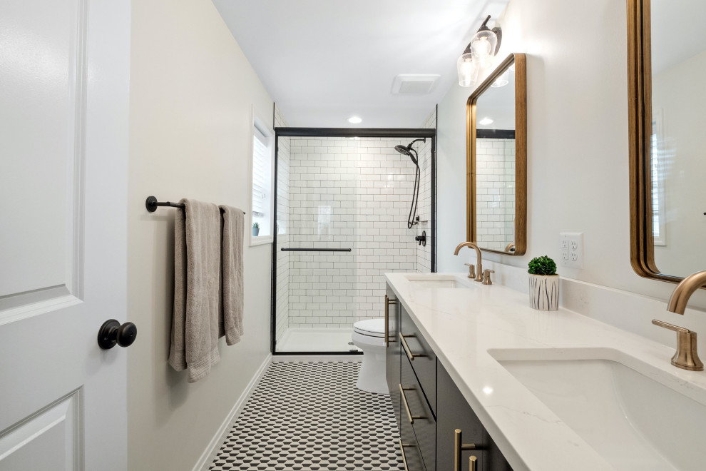 Пример оригинального дизайна: главная ванная комната среднего размера в стиле модернизм с плоскими фасадами, черными фасадами, душем в нише, раздельным унитазом, серой плиткой, керамической плиткой, бежевыми стенами, полом из керамогранита, врезной раковиной, столешницей из искусственного кварца, черным полом, душем с раздвижными дверями, белой столешницей, тумбой под две раковины и подвесной тумбой