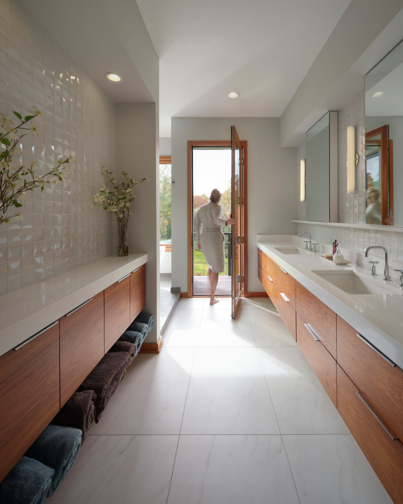 This is an example of a large contemporary master bathroom in Other with flat-panel cabinets, brown cabinets, a freestanding tub, white tile, ceramic tile, grey walls, marble floors, an undermount sink, engineered quartz benchtops, white floor, white benchtops, a double vanity and a floating vanity.