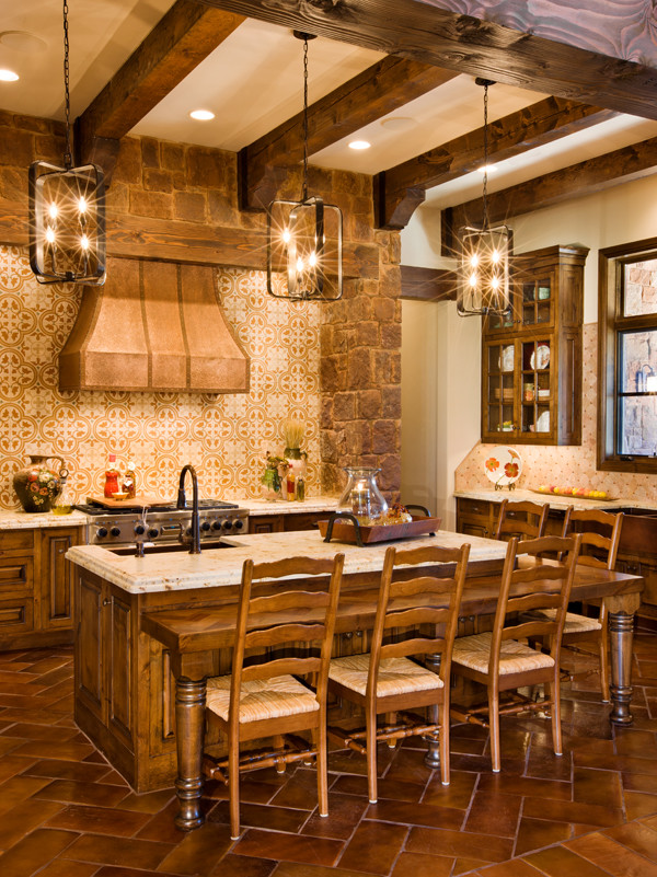 This is an example of a large country u-shaped eat-in kitchen in Austin with a farmhouse sink, raised-panel cabinets, dark wood cabinets, granite benchtops, beige splashback, ceramic splashback, stainless steel appliances, ceramic floors, with island, red floor and beige benchtop.