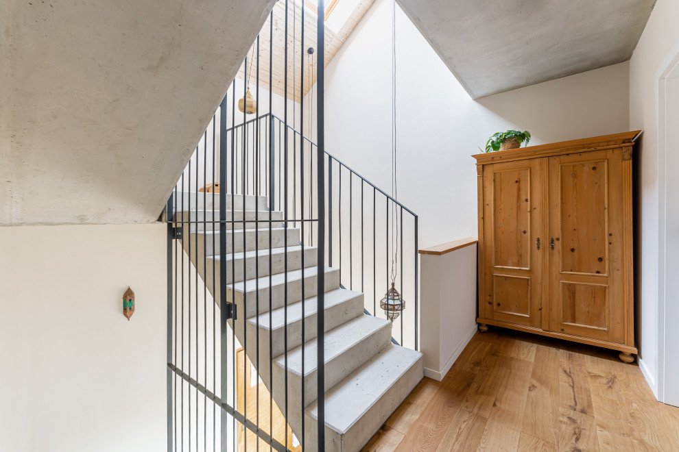 Geräumige Moderne Betontreppe in U-Form mit Beton-Setzstufen und Stahlgeländer in Frankfurt am Main