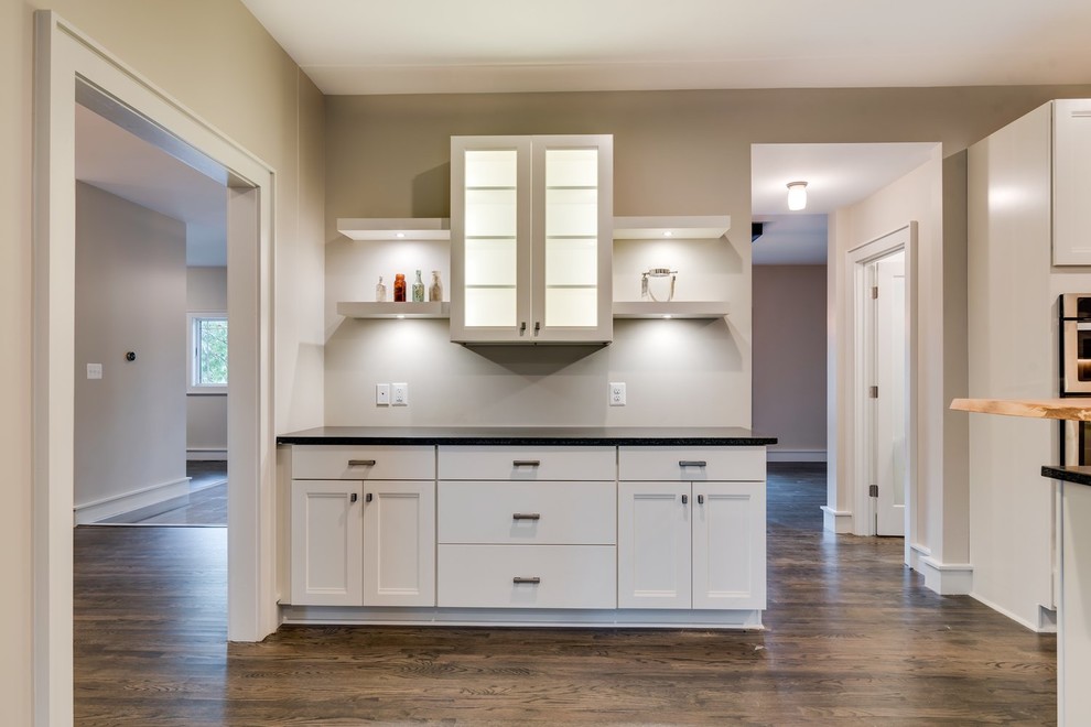 Eat-in kitchen - transitional u-shaped medium tone wood floor and multicolored floor eat-in kitchen idea in DC Metro with shaker cabinets, white cabinets, granite countertops, an island and black countertops