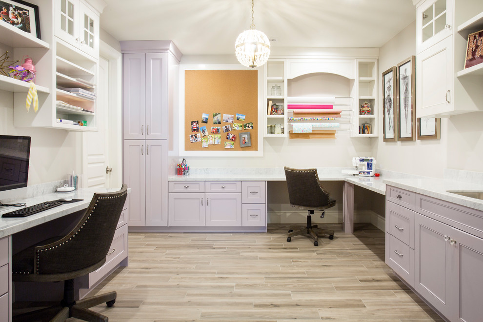 Photo of a transitional craft room in Salt Lake City with white walls, a built-in desk and grey floor.