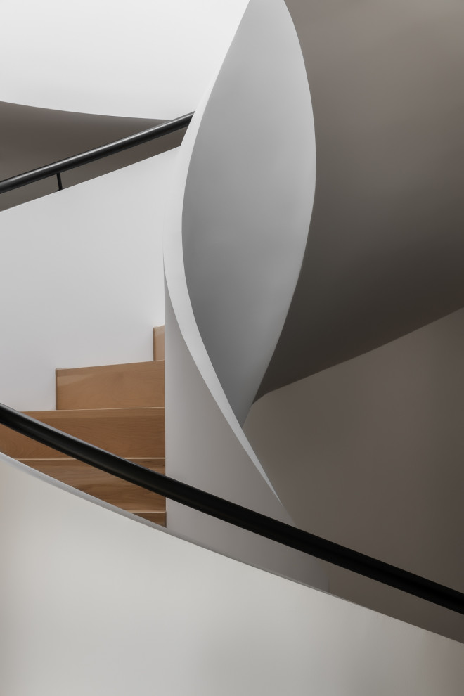 Ispirazione per una scala curva minimal di medie dimensioni con pedata in legno, alzata in legno, parapetto in metallo e pareti in mattoni