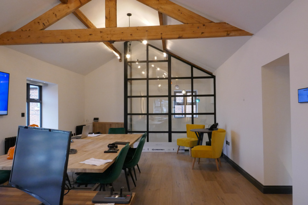 Пример оригинального дизайна: большое рабочее место в современном стиле с белыми стенами, отдельно стоящим рабочим столом, бежевым полом и сводчатым потолком