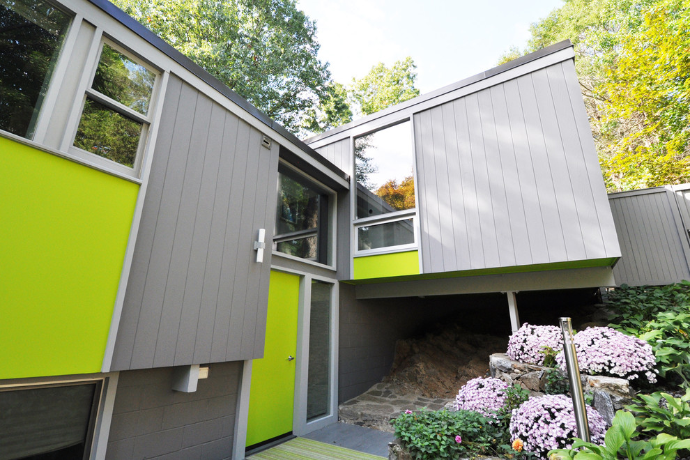Inspiration for a large modern split-level grey exterior in New York with wood siding and a flat roof.