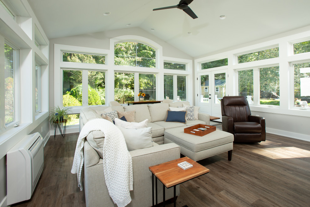 Photo of a large traditional conservatory in DC Metro with vinyl flooring, a ribbon fireplace, a metal fireplace surround, a standard ceiling and brown floors.