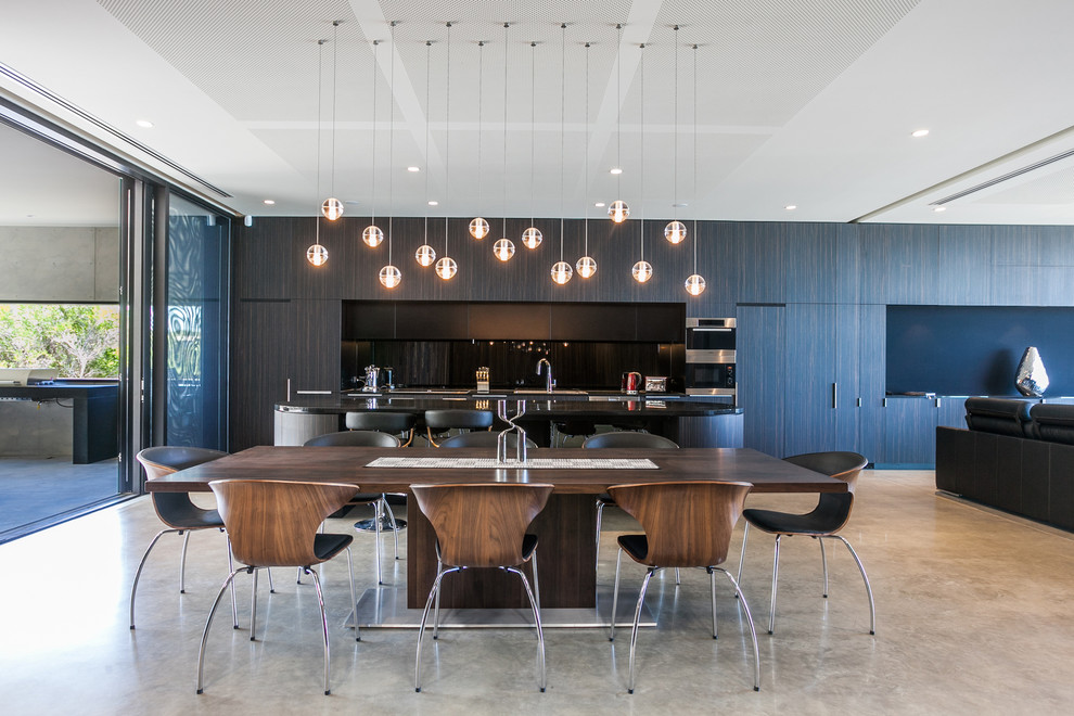 Design ideas for a contemporary dining room in Geelong with brown walls and concrete floors.