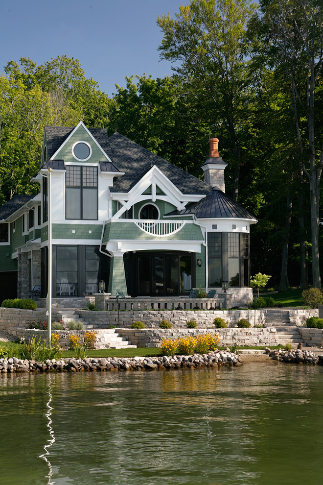This is an example of a large arts and crafts two-storey green exterior in Chicago with wood siding.
