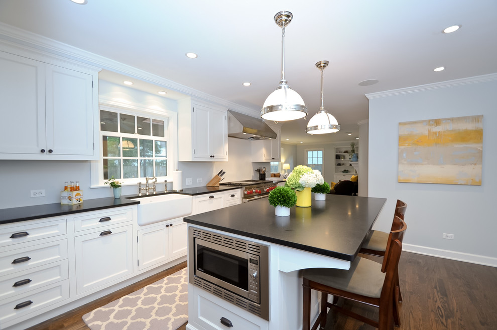 Design ideas for a traditional kitchen in Chicago with a farmhouse sink, recessed-panel cabinets, white cabinets and stainless steel appliances.