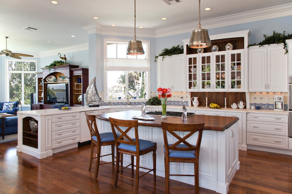 Inspiration for a beach style open plan kitchen in Sacramento with recessed-panel cabinets, white cabinets, wood benchtops, beige splashback, dark hardwood floors and with island.