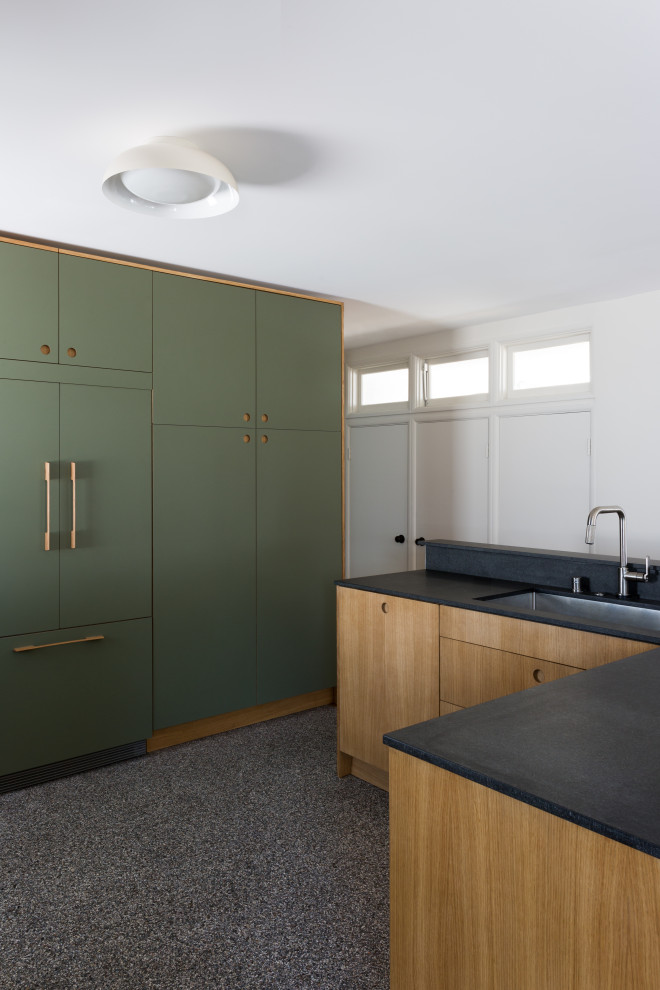 Photo of a small midcentury l-shaped kitchen in Los Angeles with a submerged sink, flat-panel cabinets, green cabinets, granite worktops, white splashback, ceramic splashback, terrazzo flooring, an island, multi-coloured floors and black worktops.