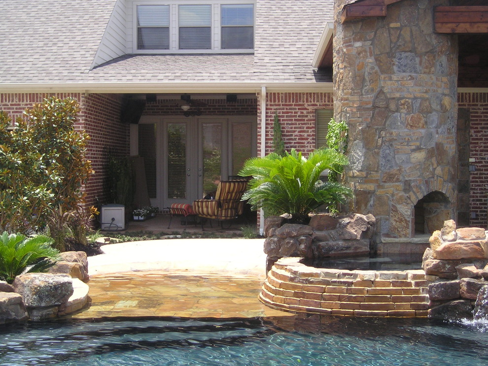 Photo of a large arts and crafts backyard custom-shaped natural pool in Dallas with a hot tub and concrete slab.