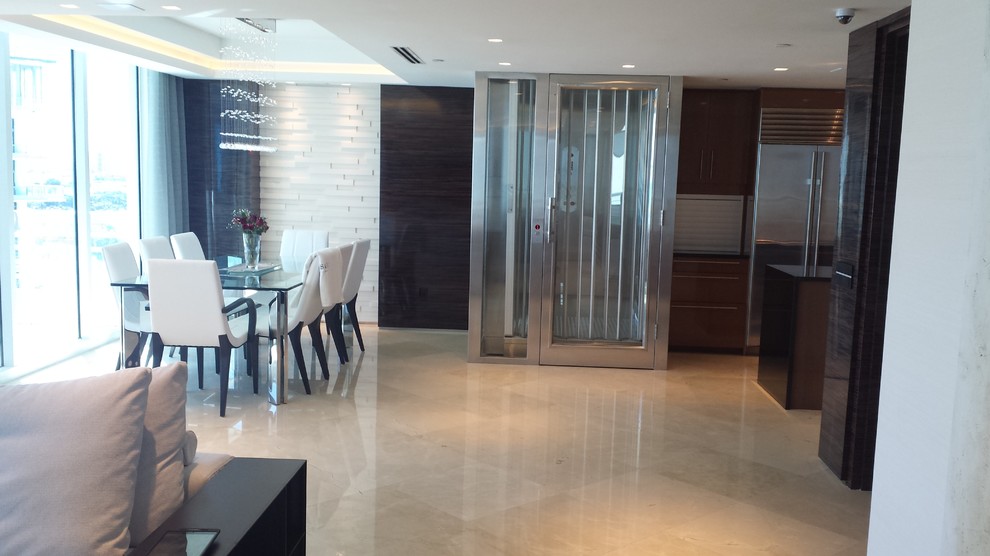 Photo of a large contemporary entryway in Miami with beige walls and marble floors.
