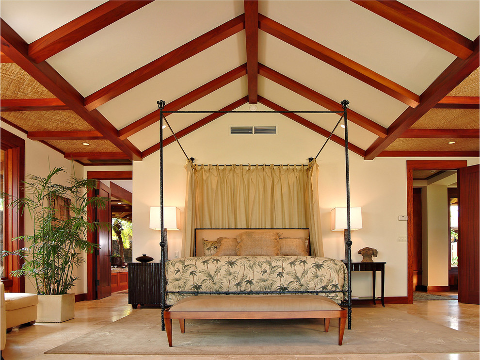 Inspiration for a large tropical master bedroom in Hawaii with beige walls, travertine floors and beige floor.