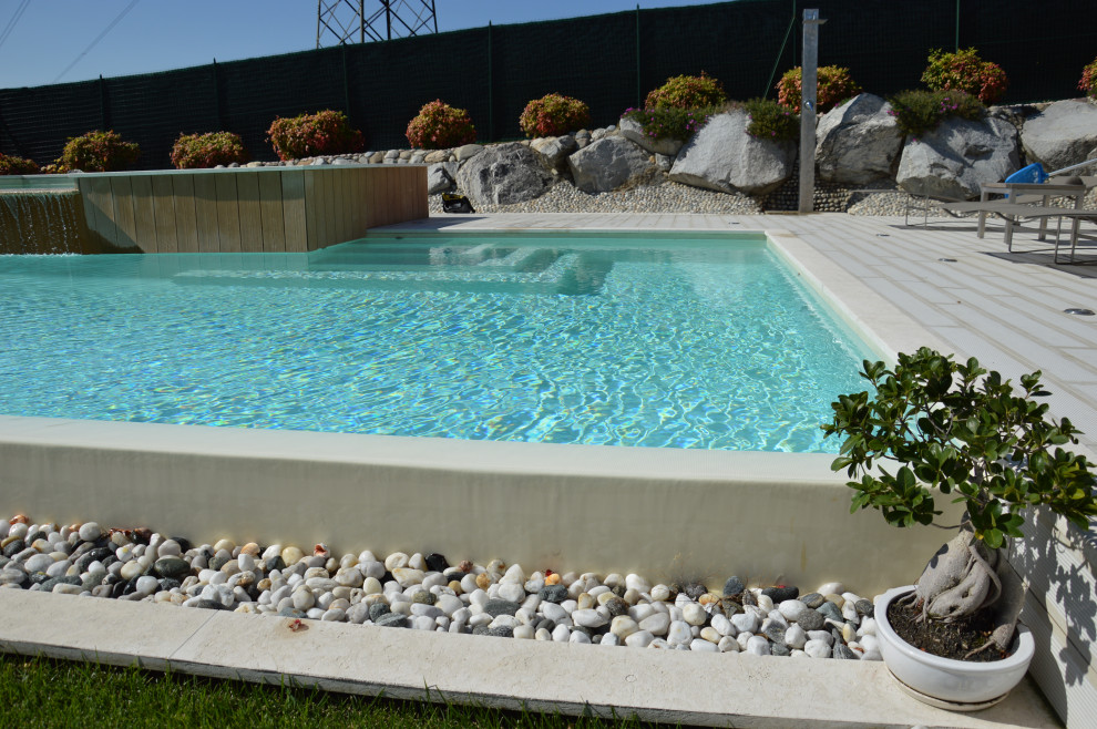 Esempio di una grande piscina a sfioro infinito minimalista rettangolare con piastrelle