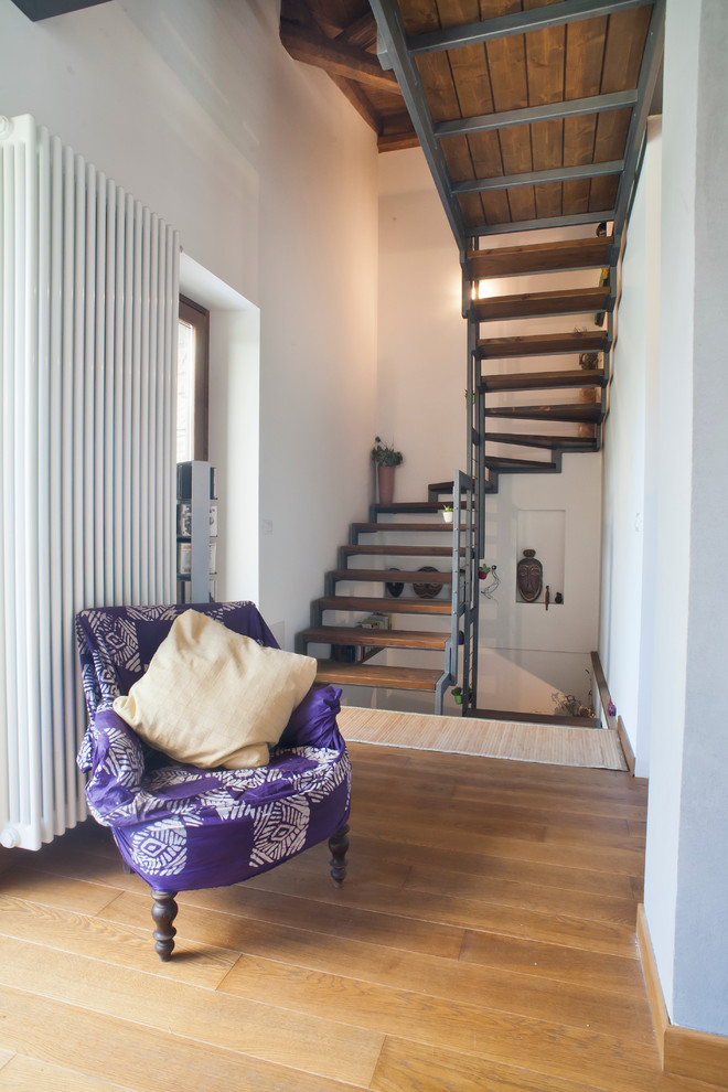 This is an example of a mid-sized modern wood u-shaped staircase in Milan with open risers.