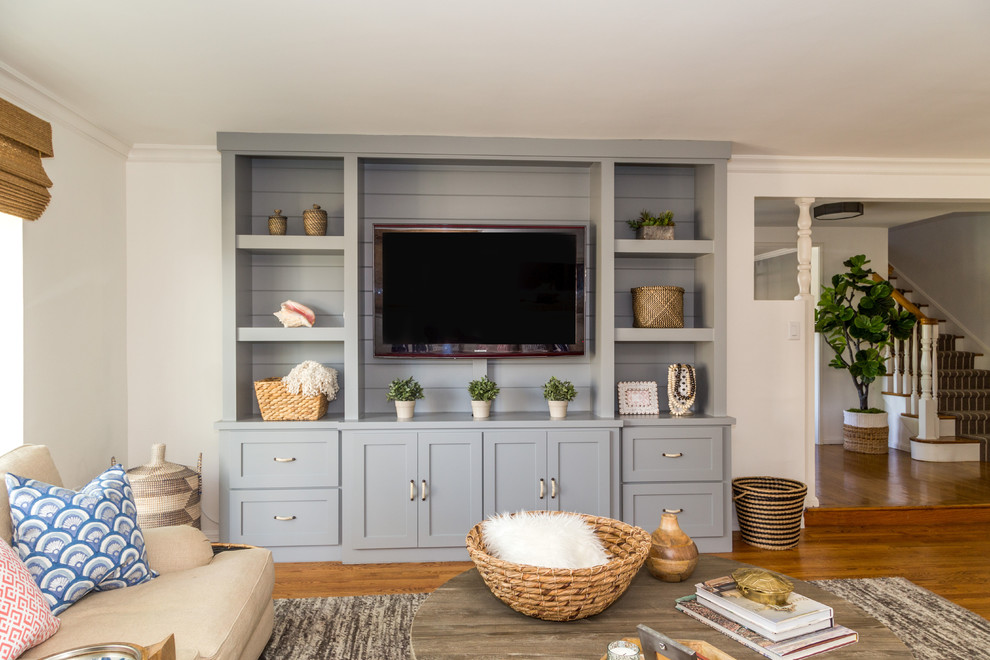 This is an example of a mid-sized transitional open concept family room in Orange County with beige walls, medium hardwood floors and a built-in media wall.
