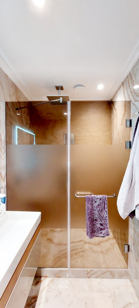 Идея дизайна: ванная комната среднего размера в современном стиле с плоскими фасадами, коричневыми фасадами, душем без бортиков, инсталляцией, бежевой плиткой, керамогранитной плиткой, коричневыми стенами, полом из керамогранита, душевой кабиной, накладной раковиной, бежевым полом, душем с распашными дверями, зеркалом с подсветкой, тумбой под одну раковину и подвесной тумбой
